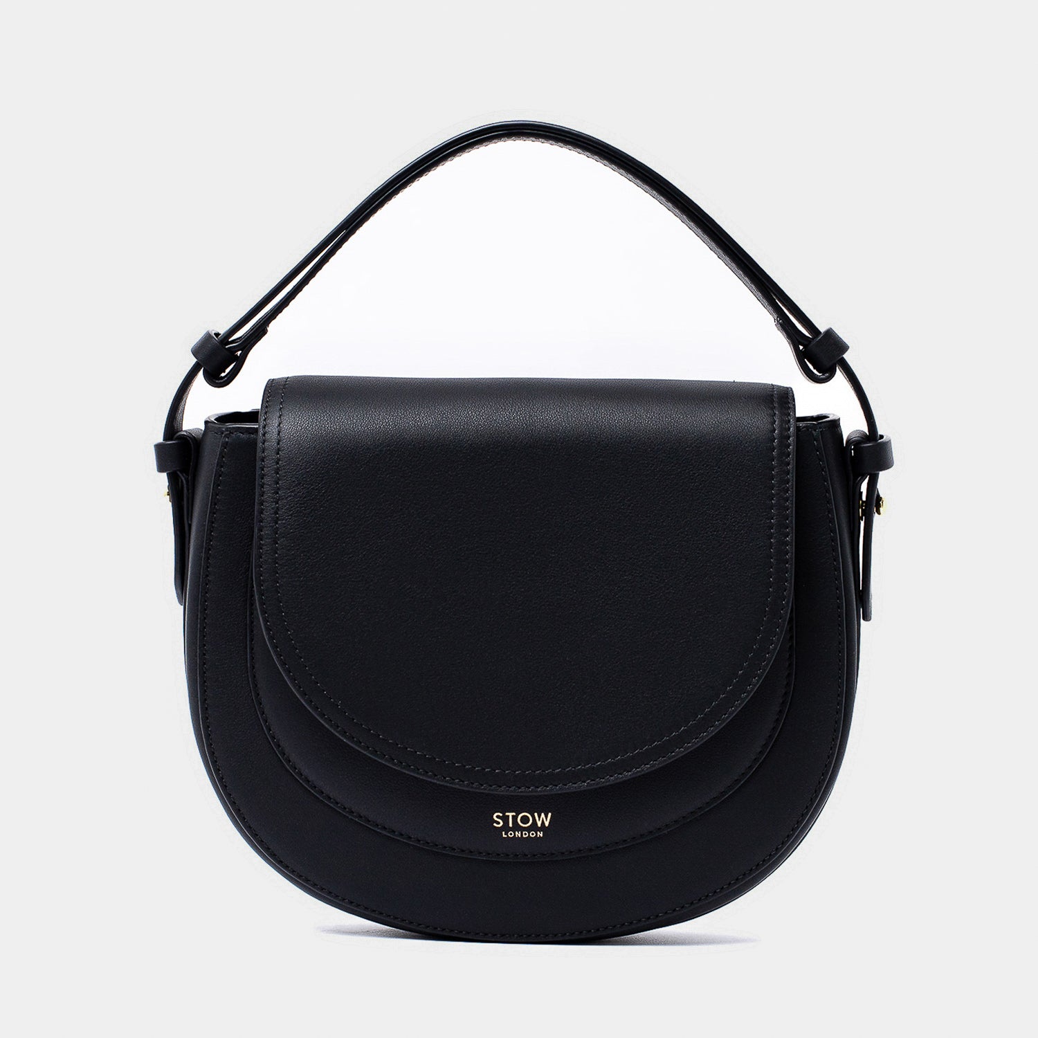 STOW London's Saddle bag in Black smooth leather with its short top handle on a light grey background