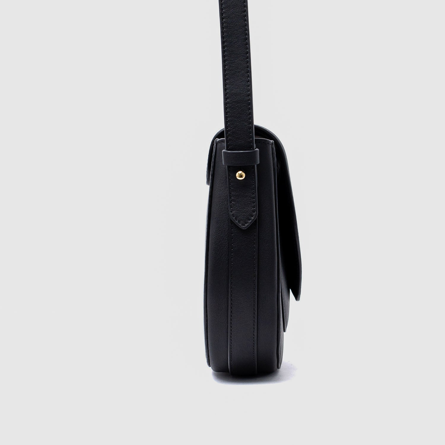 Side view of STOW London's Saddle bag in Black smooth leather on a light grey background