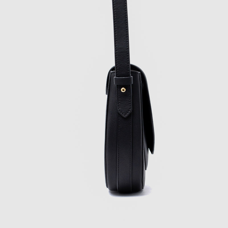 Side view of STOW London's Saddle bag in Black smooth leather on a light grey background