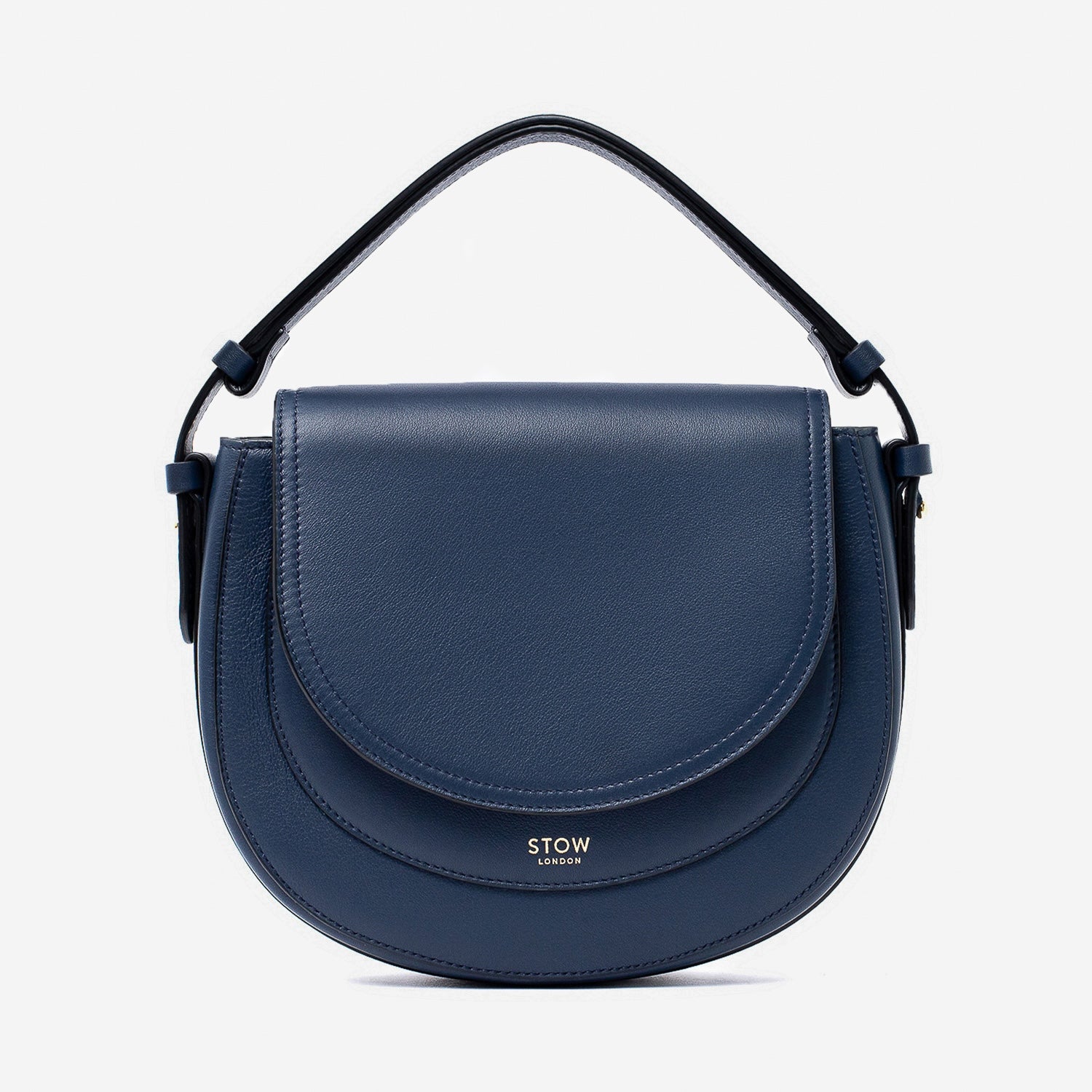 STOW London's Saddle bag in Navy smooth leather with its short top handle on a light grey background