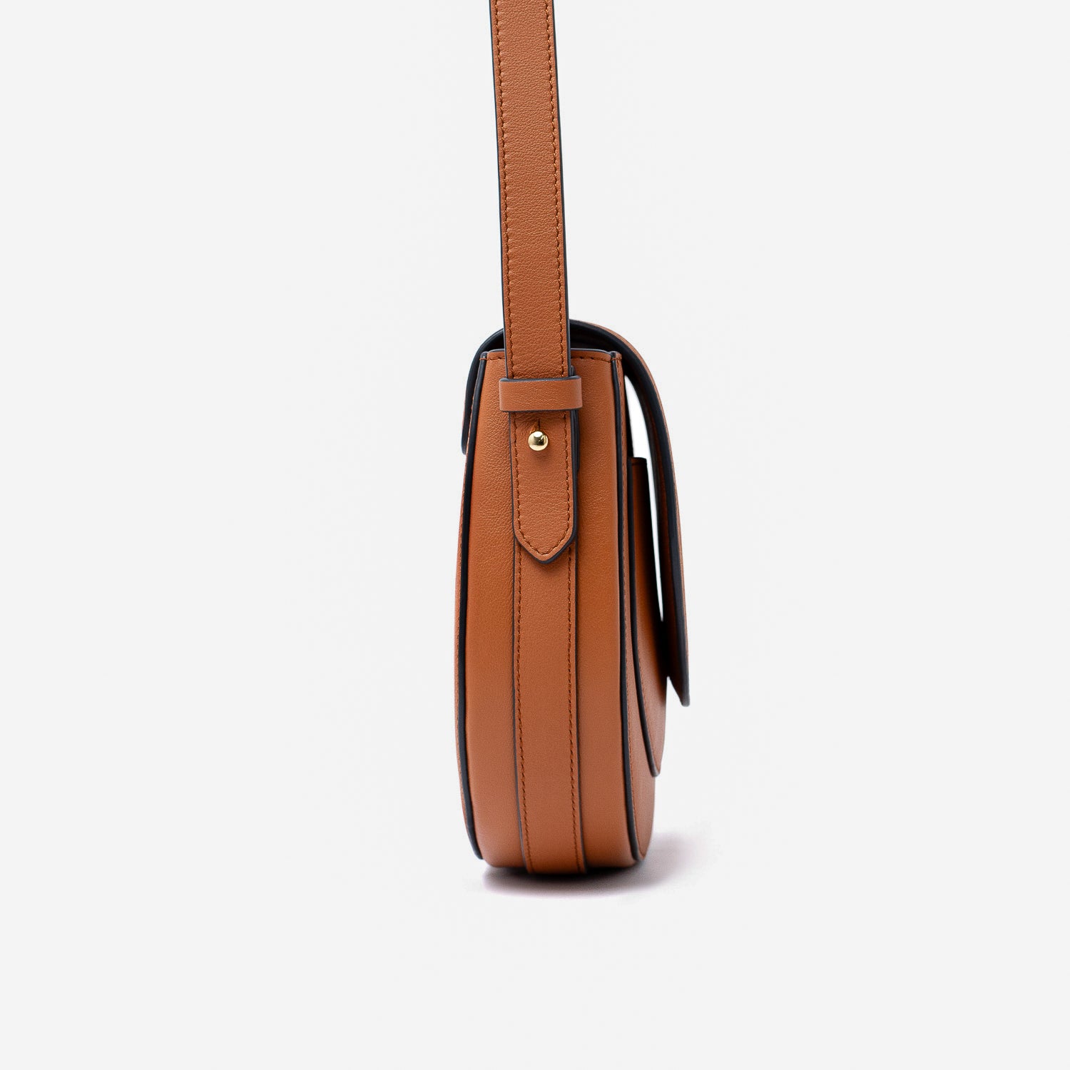 Side view of STOW London's Saddle bag in Earth Tan smooth leather on a light grey background