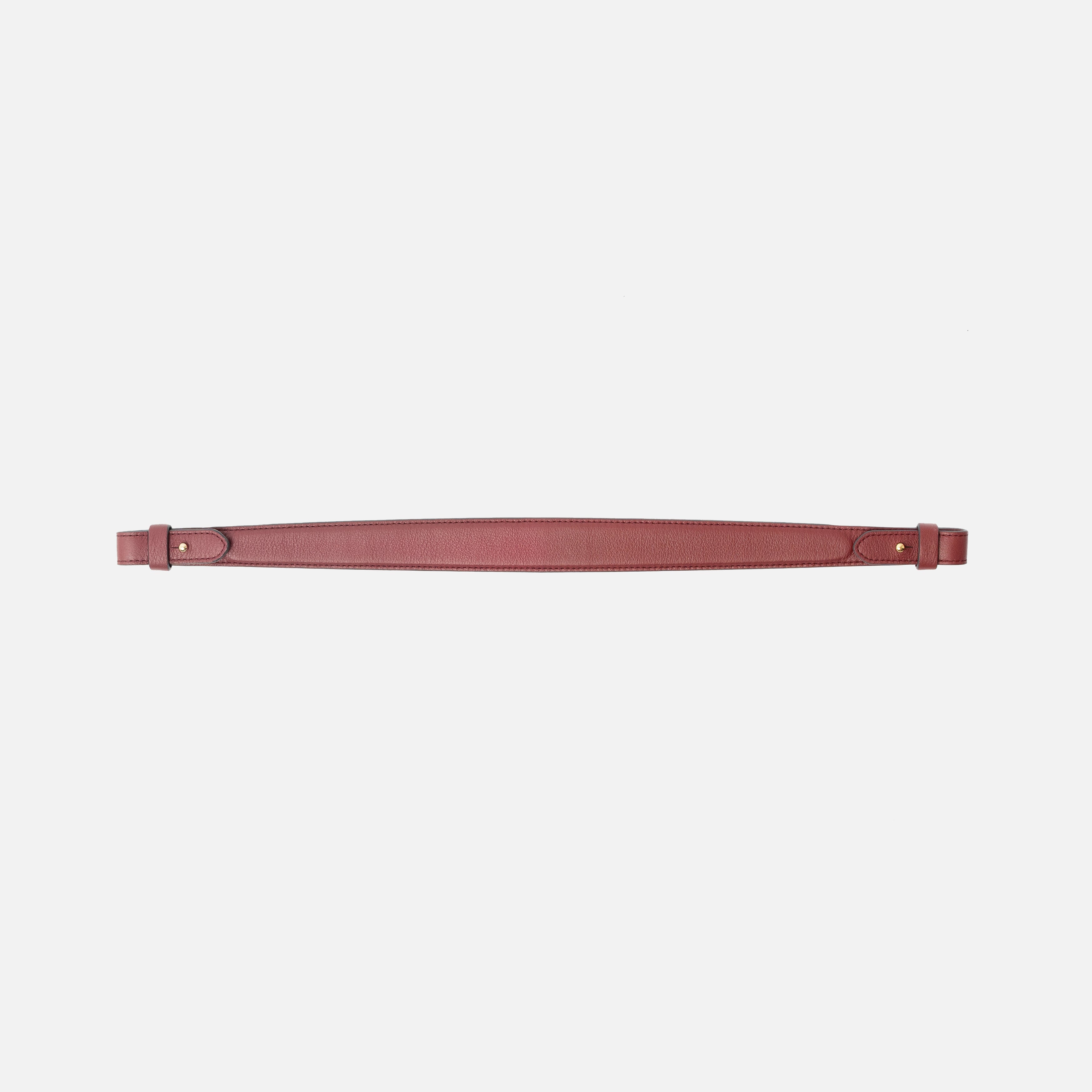 Detachable shoulder strap for STOW London's Curve, Midi Curve and East West in Burgundy smooth leather on a light grey background featuring gold hardware 