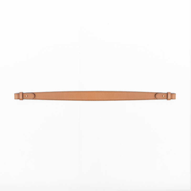 Detachable shoulder strap for STOW London's Curve, Midi Curve and East West in Earth Tan smooth leather on a light grey background featuring gold hardware 