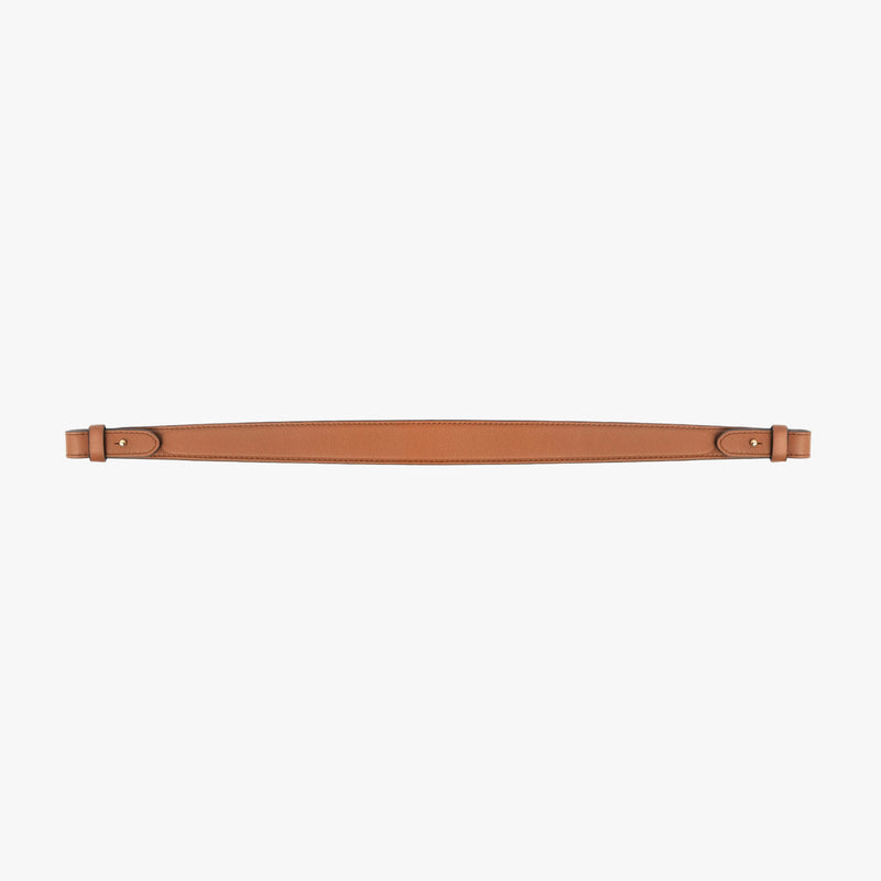 Detachable shoulder strap for STOW London's Curve, Midi Curve and East West in Earth Tan smooth leather on a light grey background featuring gold hardware 