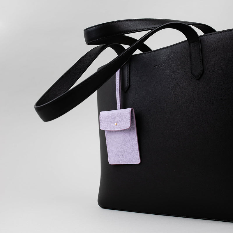 STOW Leather Multi Tag in Wild Lavender pebbled leather shown hanging on Black Everyday Tote Bag by STOW.