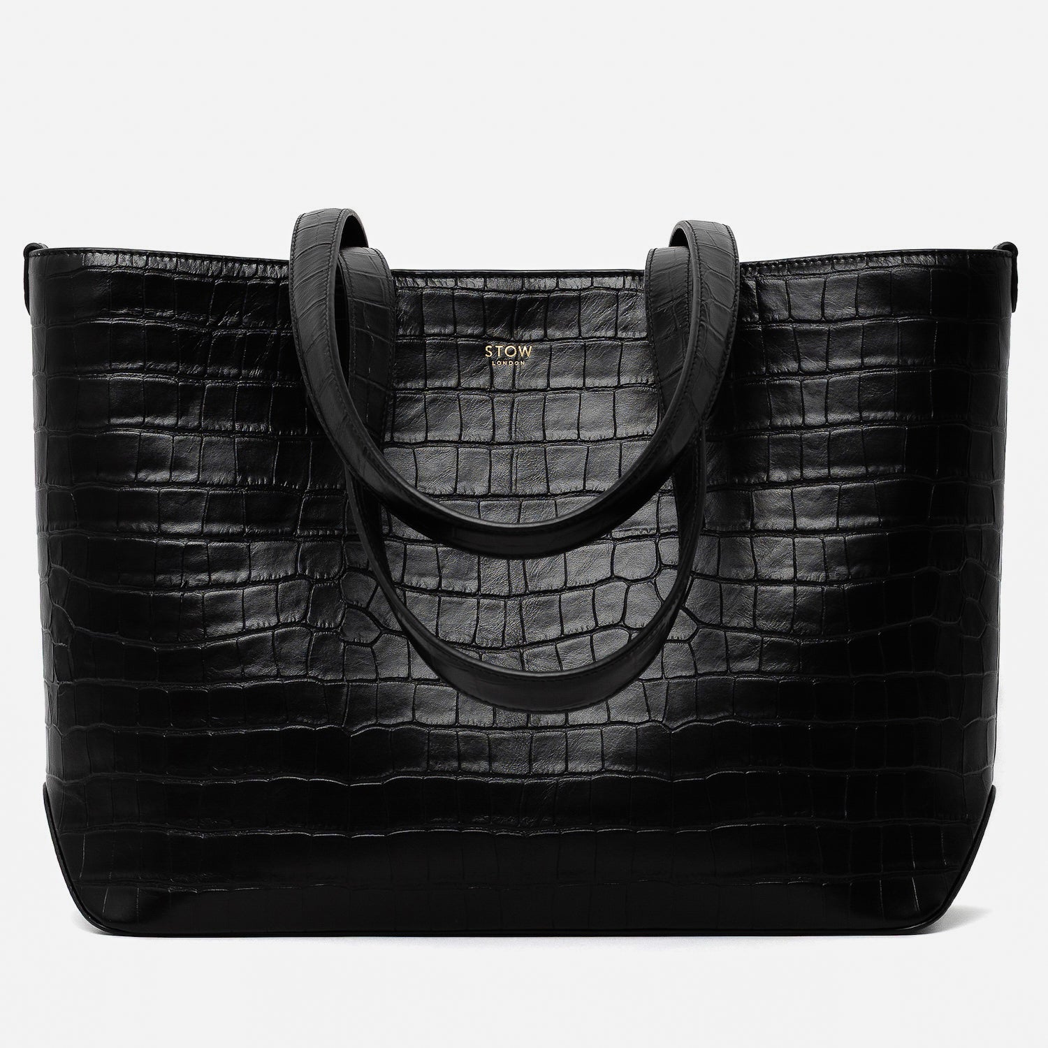 Stow London's Everyday Tote Bag in Black Embossed Croc leather on a light grey background featuring gold STOW logo