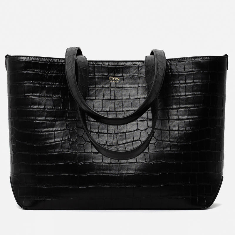 Stow London's Everyday Tote Bag in Black Embossed Croc leather on a light grey background featuring gold STOW logo