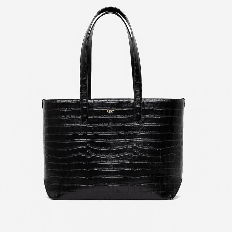 Stow London's Everyday Tote Bag in Black Embossed Croc leather on a light grey background featuring gold STOW logo