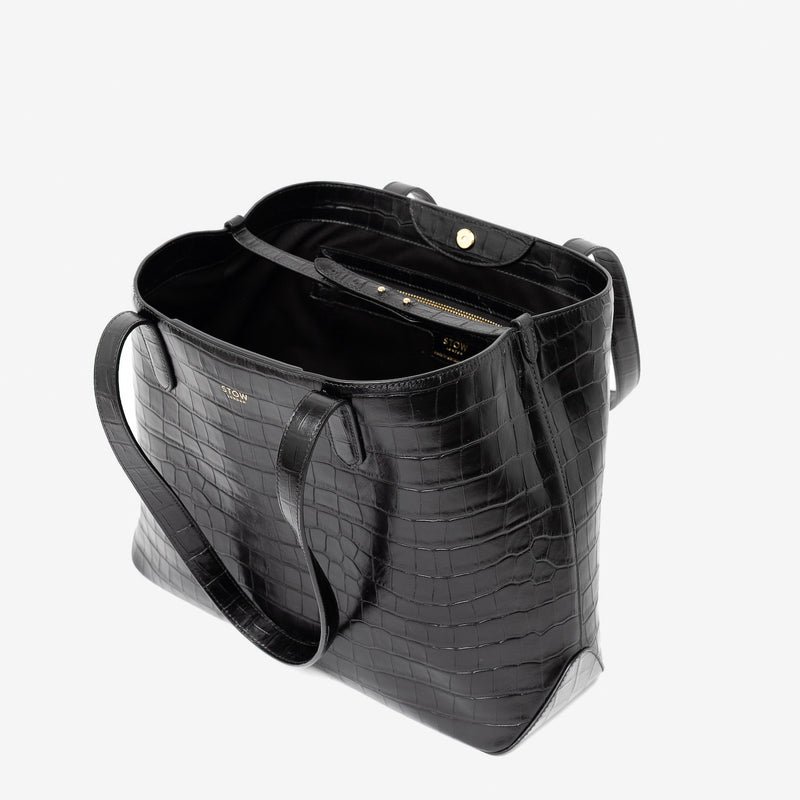 Stow London's Everyday Tote Bag in Black Embossed Croc leather on a light grey background with magnets open showing black cotton interior, leather strap, magnetic closure and zip pocket
