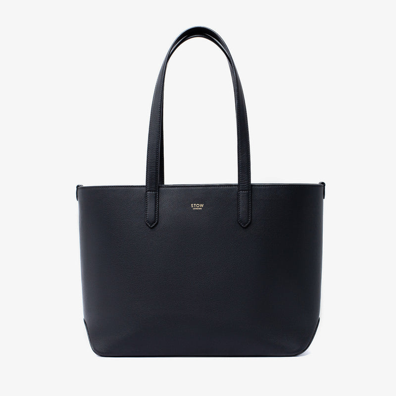 Stow London's Everyday Tote Bag in Black smooth leather on a light grey background featuring gold STOW logo