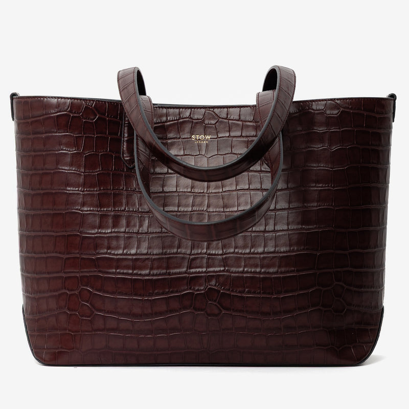 Stow London's Everyday Tote Bag in Burgundy Embossed Croc leather on a light grey background featuring gold STOW logo
