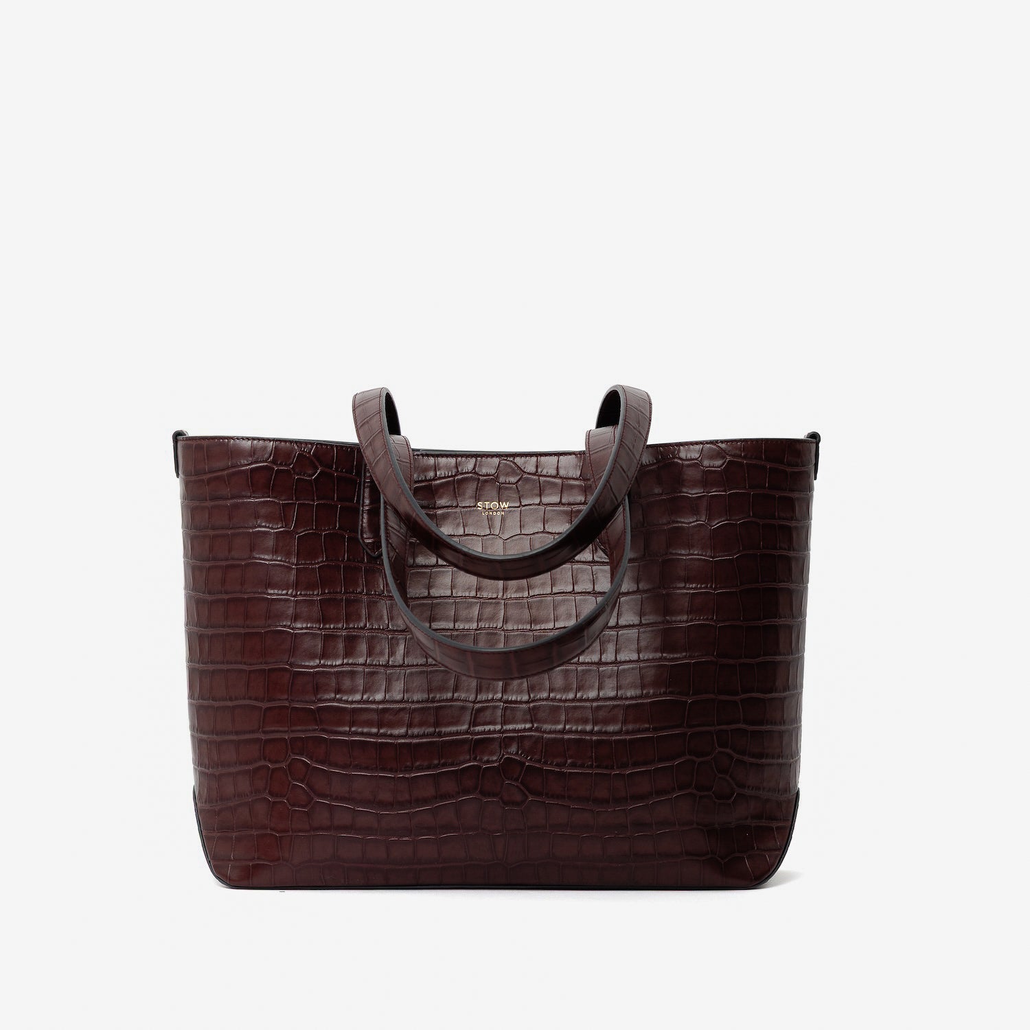 Stow London's Everyday Tote Bag in Burgundy Embossed Croc leather on a light grey background featuring gold STOW logo