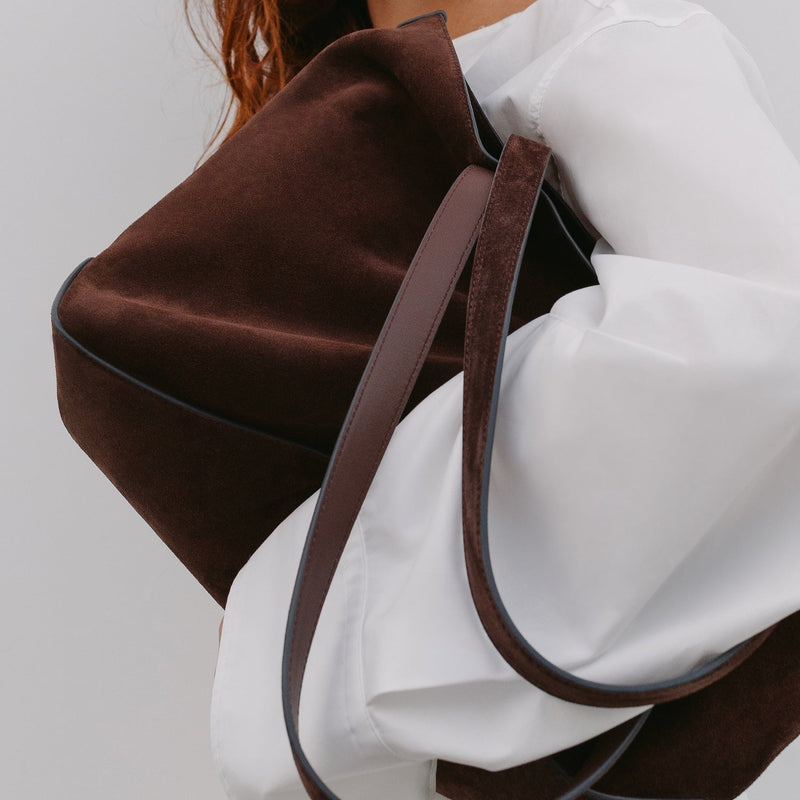 Model holding in her arms STOW London's Everyday Tote bag in Chocolate suede 
