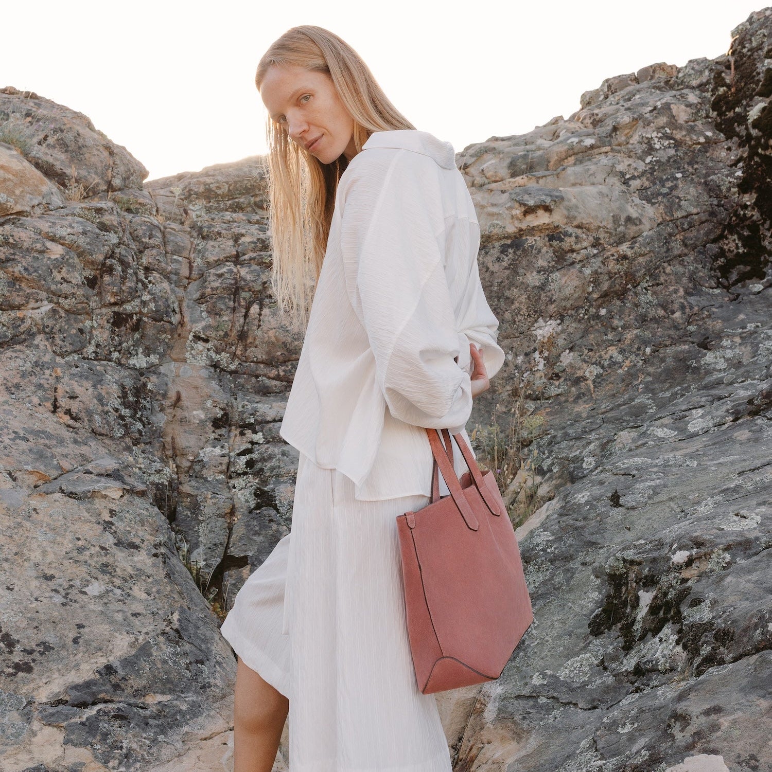 Model with STOW London's Everyday Tote bag in Hazy Blush suede featuring a small STOW London logo embossed on the front panel 
