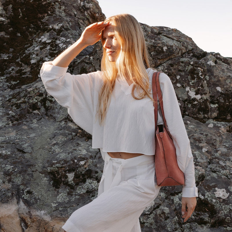 Model with STOW London's Everyday Tote bag in Hazy Blush suede featuring a small STOW London logo embossed on the front panel 