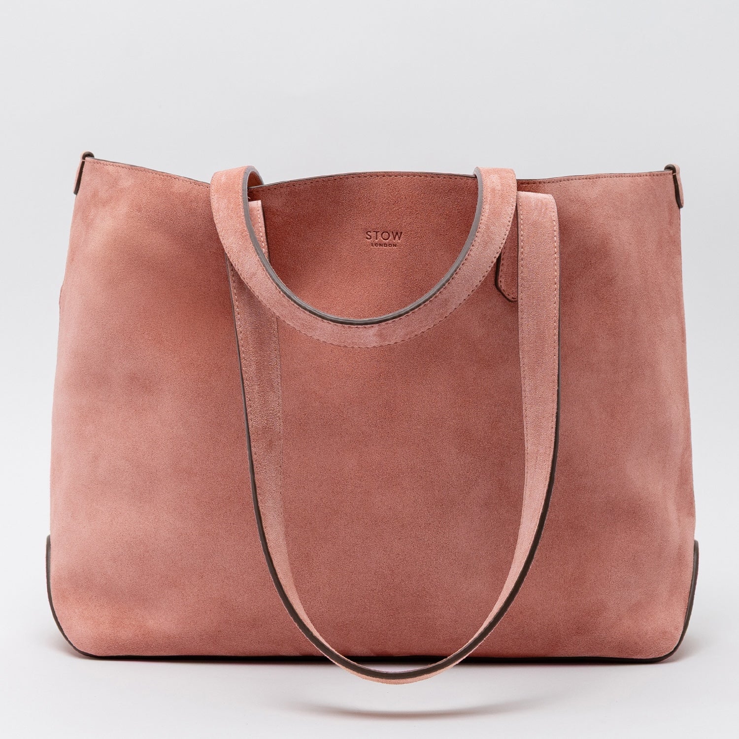 STOW London's Everyday Tote bag in Hazy Blush suede on a light grey background featuring a small STOW London logo embossed on the front panel 