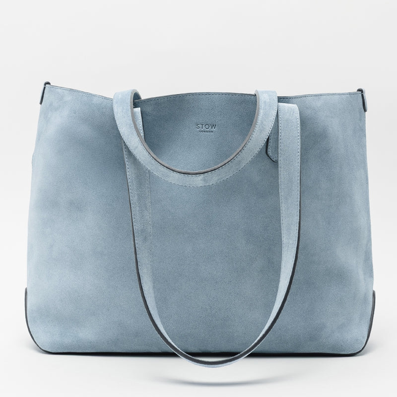 STOW London's Everyday Tote bag in Misty Blue suede on a light grey background featuring a small STOW London logo embossed on the front panel 