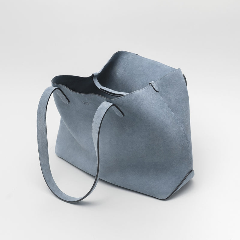 STOW London's Everyday Tote bag in Misty Blue suede on a light grey background featuring the interior strap and a small STOW London logo embossed on the front panel 