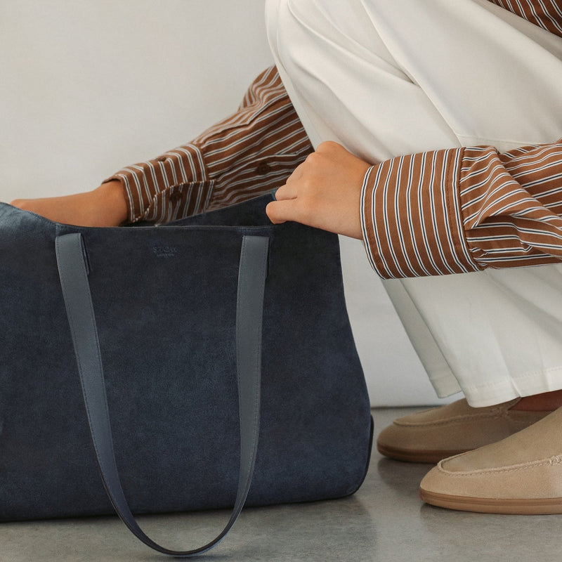 Model with STOW London's Everyday Tote bag in Navy suede featuring a small STOW London logo embossed on the front panel