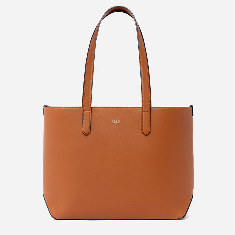 Stow London's Everyday Tote Bag in Earth Tan smooth leather on a light grey background featuring gold STOW logo