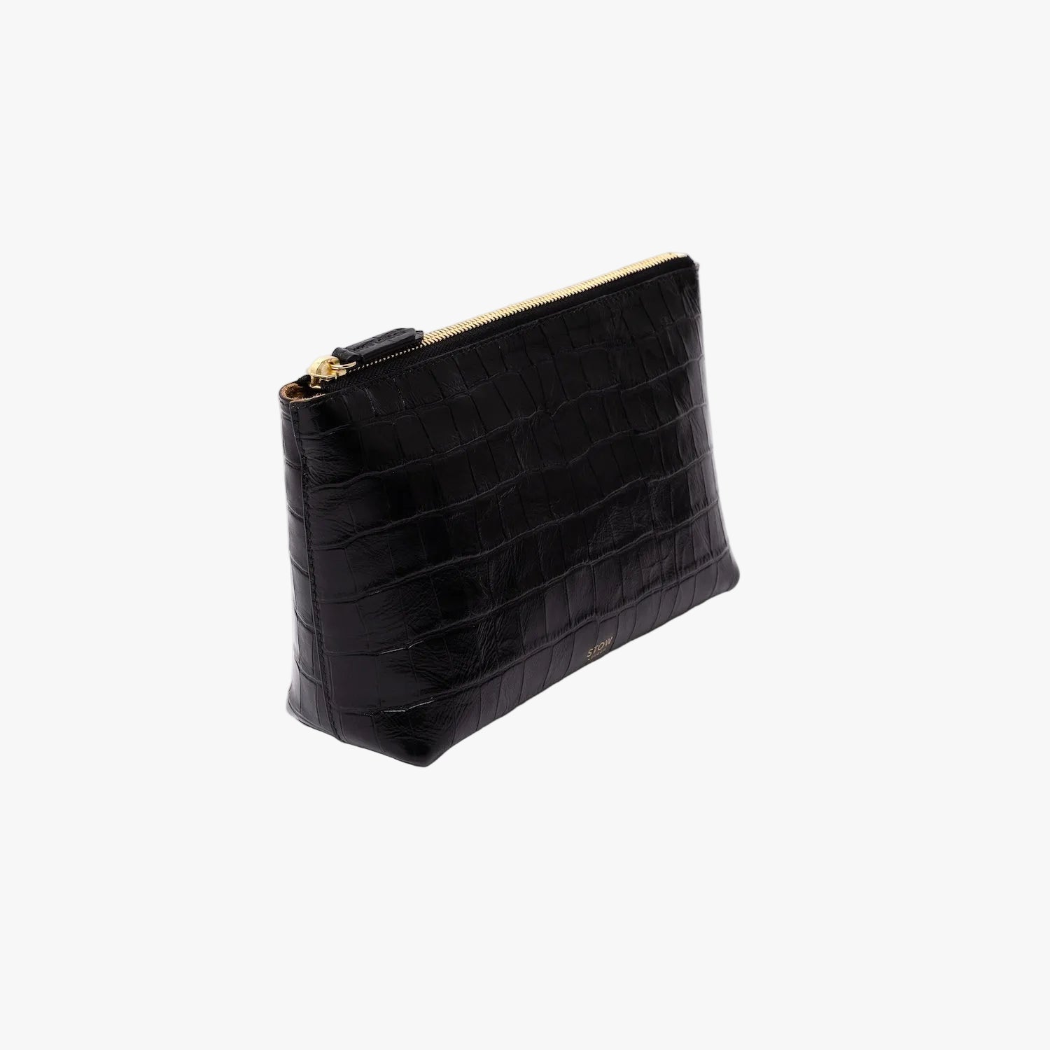 Off-axis view of STOW London's travel pouch in Black Embossed Croc leather on a light grey background featuring a YKK zip and a fine gold embossed logo on the front
