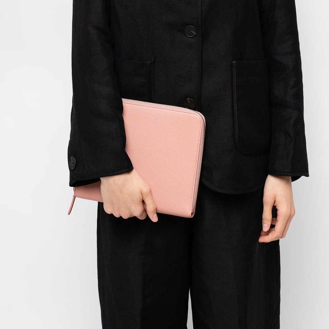 STOW London First Class Folio tech case in Hazy Blush leather carried by female model wearing all black