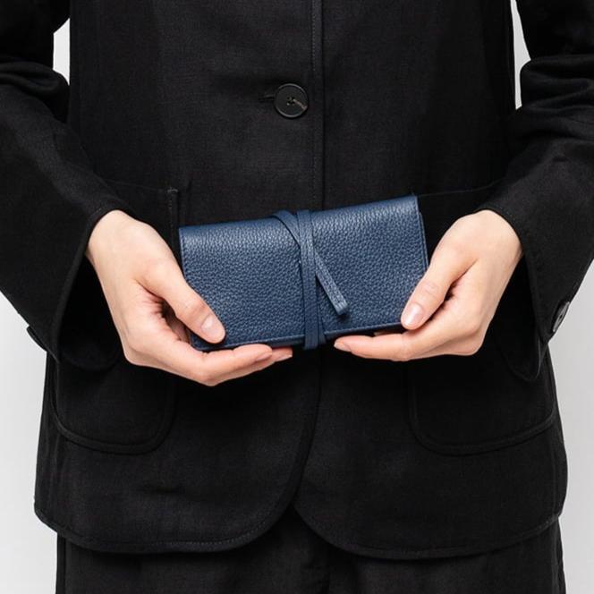 STOW London Mini Jewellery Roll in Navy leather held by female model wearing all black in studio