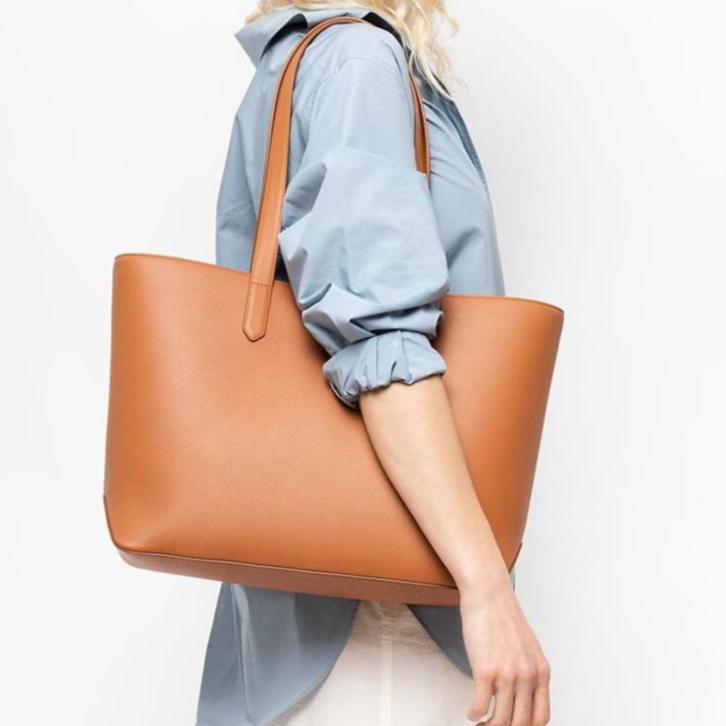 STOW London Earth Tan Leather Everyday Tote Bag, studio image with female model wearing bag