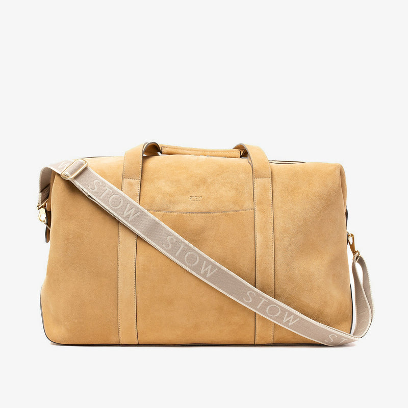STOW London's Weekend bag in Soft Sand suede leather and a detachable branded STOW webbing strap on a light grey background