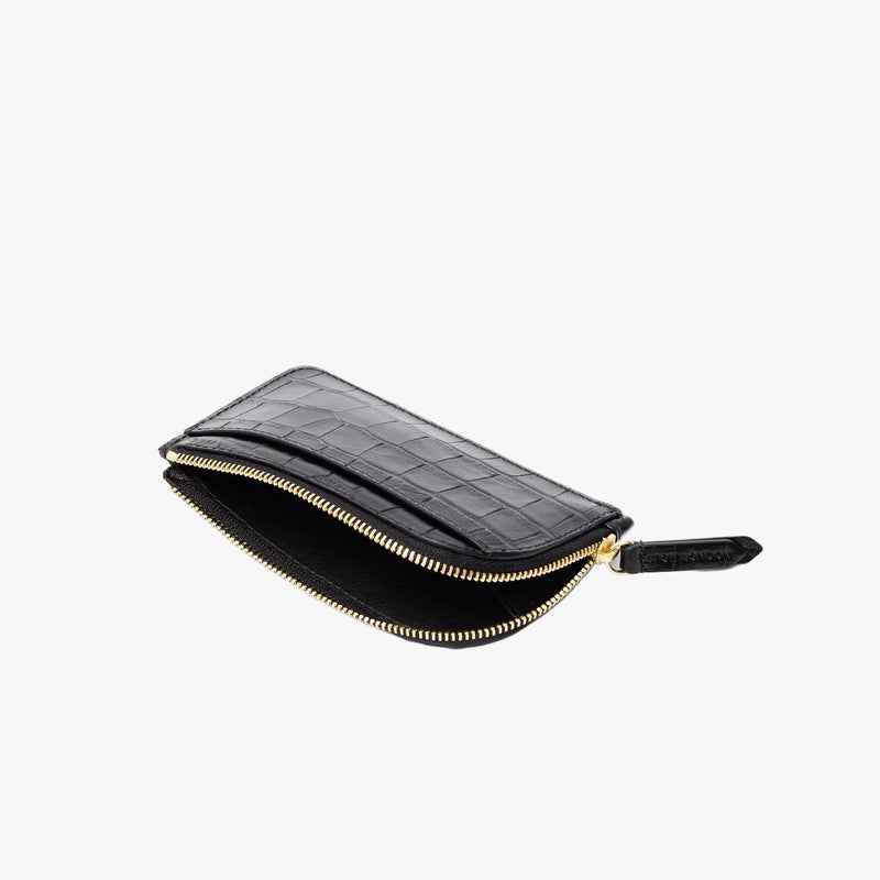 STOW London's Zip Wallet in Black Embossed Croc leather on a light grey background with zipper open showing interior of wallet