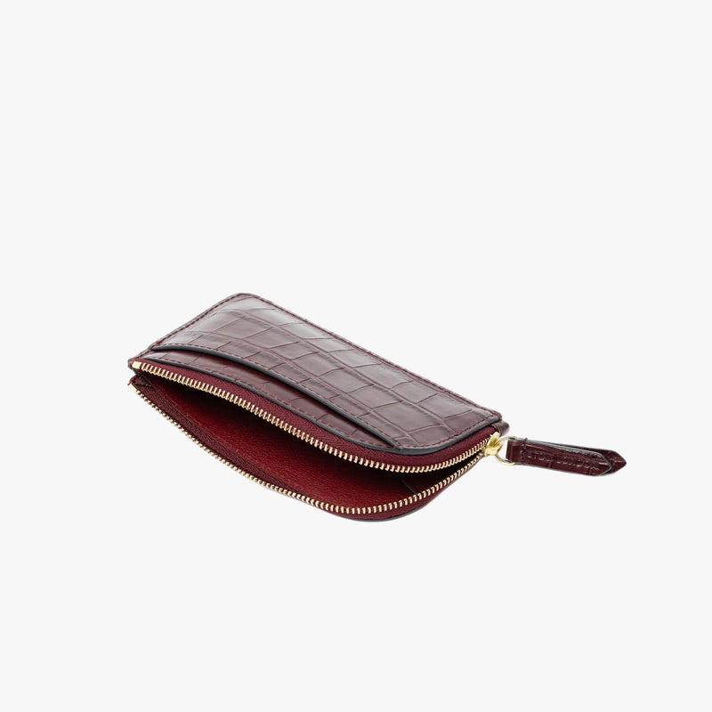 STOW London's Zip Wallet in Burgundy Embossed Croc leather on a light grey background with zipper open showing interior