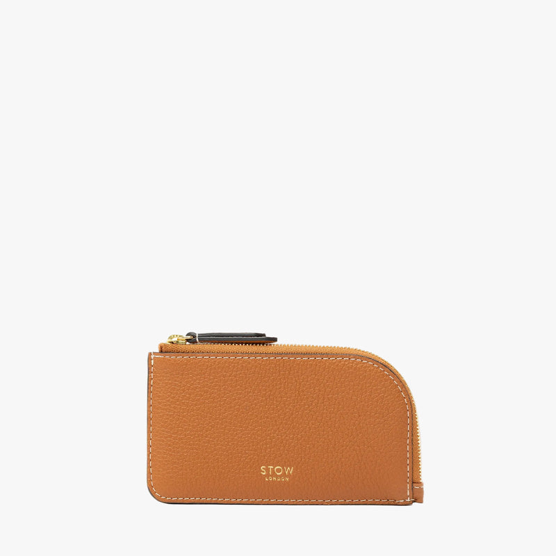 STOW London's Zip Wallet in Earth Tan pebbled leather on a light grey background featuring a fine gold embossed logo and YKK Natulon zipper